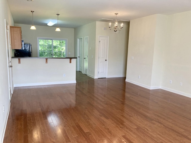 507 Whirlaway Ct, Burns, TN 37029 - unfurnished living room with a chandelier and dark wood-style floors