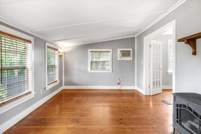256 Tanksley Ave, Nashville, TN 37211 - unfurnished room featuring a wood stove, ornamental molding, an AC wall unit, wood finished floors, and baseboards