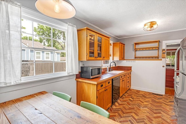 256 Tanksley Ave, Nashville, TN 37211 - kitchen featuring appliances with stainless steel finishes, a sink, brick floors, a wainscoted wall, and ornamental molding