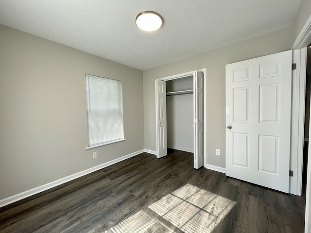 1004 E Railroad St, Waverly, TN 37185 - unfurnished bedroom featuring dark wood-type flooring, baseboards, and a closet