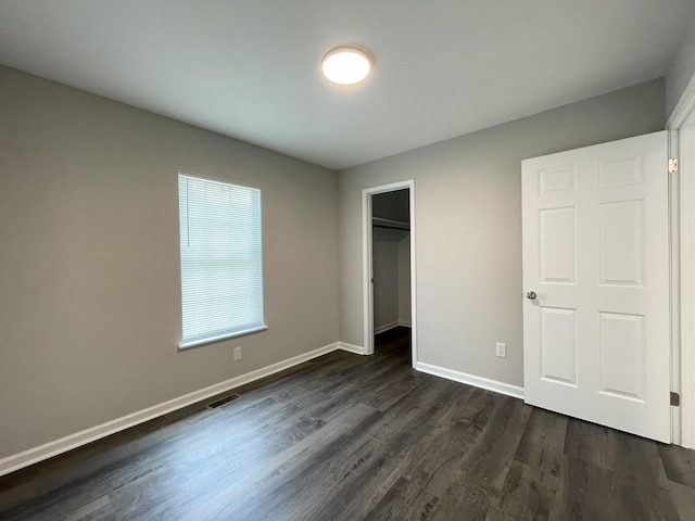 1004 E Railroad St, Waverly, TN 37185 - unfurnished bedroom featuring dark wood-style floors, baseboards, and a closet