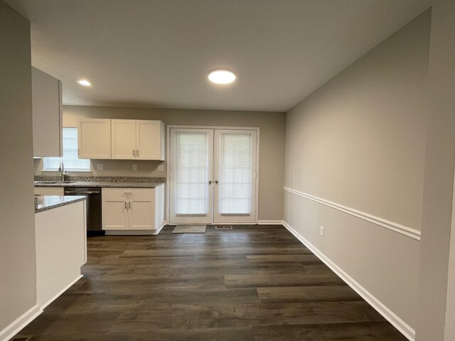 1004 E Railroad St, Waverly, TN 37185 - kitchen with stainless steel dishwasher, french doors, white cabinetry, light stone countertops, and a sink