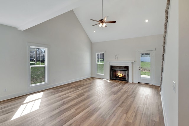 1038 Camden Trl, Greenbrier, TN 37073 - unfurnished living room with high vaulted ceiling, healthy amount of natural light, ceiling fan, a fireplace with flush hearth, and light wood finished floors