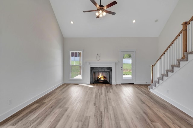 1038 Camden Trl, Greenbrier, TN 37073 - unfurnished living room with high vaulted ceiling, healthy amount of natural light, light wood-type flooring, stairs, and recessed lighting
