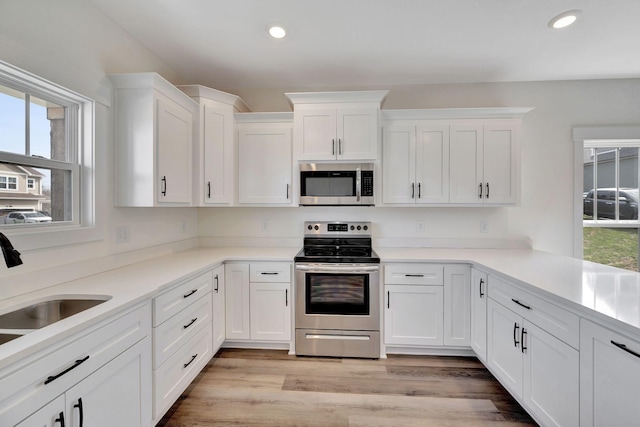 1038 Camden Trl, Greenbrier, TN 37073 - kitchen featuring stainless steel appliances, white cabinetry, recessed lighting, a sink, and light wood-type flooring