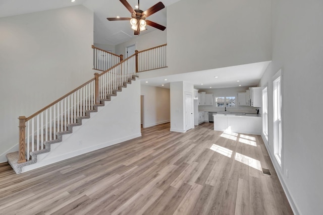 1038 Camden Trl, Greenbrier, TN 37073 - unfurnished living room featuring high vaulted ceiling, light wood-style flooring, a ceiling fan, stairs, and baseboards