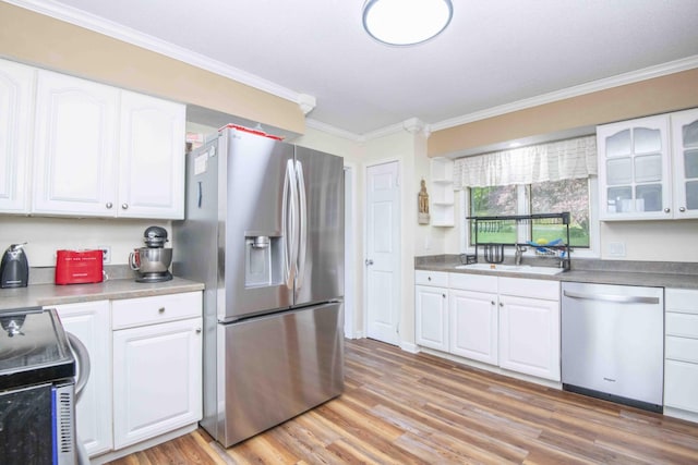 813 Stiner Ln, La Follette, TN 37766 - kitchen with appliances with stainless steel finishes, a sink, white cabinetry, ornamental molding, and light wood-type flooring