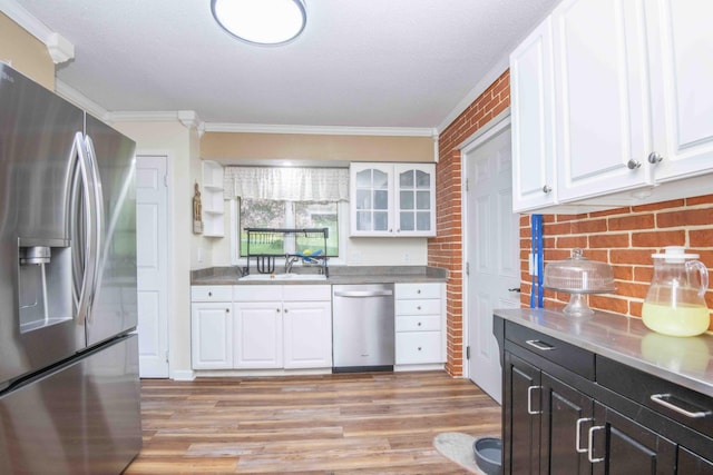 813 Stiner Ln, La Follette, TN 37766 - kitchen featuring appliances with stainless steel finishes, ornamental molding, a sink, white cabinets, and light wood-type flooring