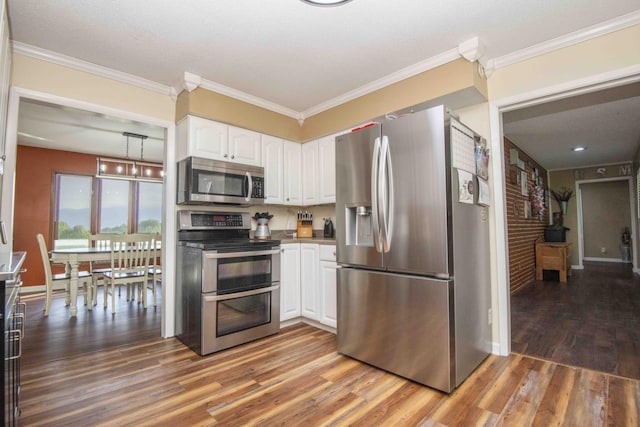 813 Stiner Ln, La Follette, TN 37766 - kitchen with appliances with stainless steel finishes, white cabinets, light wood-style flooring, baseboards, and ornamental molding