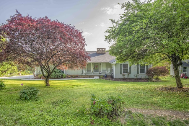 813 Stiner Ln, La Follette, TN 37766 - view of property hidden behind natural elements featuring covered porch, a front lawn, and a chimney
