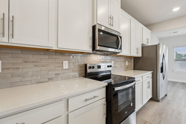 4232 Skyridge Dr, Nashville, TN 37207 - kitchen with appliances with stainless steel finishes, white cabinets, light countertops, decorative backsplash, and recessed lighting