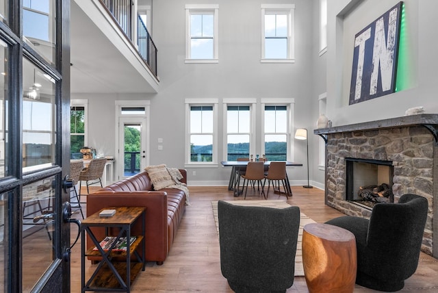 179 Deer Path Ct, Smithville, TN 37166 - living area featuring a high ceiling, wood finished floors, a stone fireplace, and baseboards