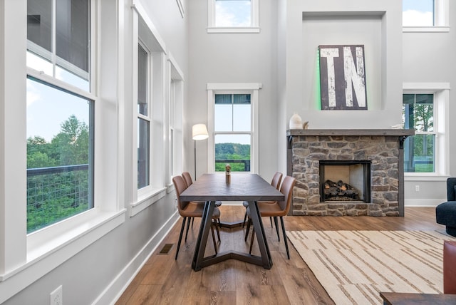 179 Deer Path Ct, Smithville, TN 37166 - dining room with a towering ceiling, a stone fireplace, wood finished floors, and healthy amount of natural light