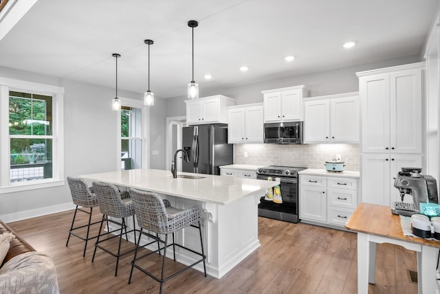 179 Deer Path Ct, Smithville, TN 37166 - kitchen with appliances with stainless steel finishes, white cabinets, a kitchen bar, tasteful backsplash, and recessed lighting