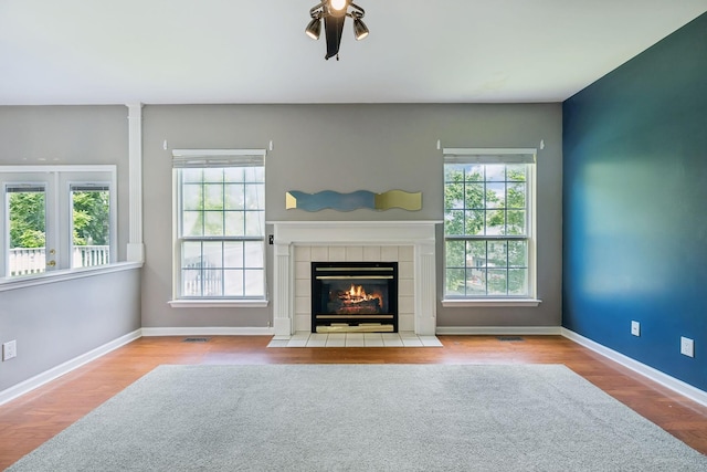 205 Caneel Cv, Hermitage, TN 37076 - unfurnished living room featuring wood finished floors, a tiled fireplace, and baseboards