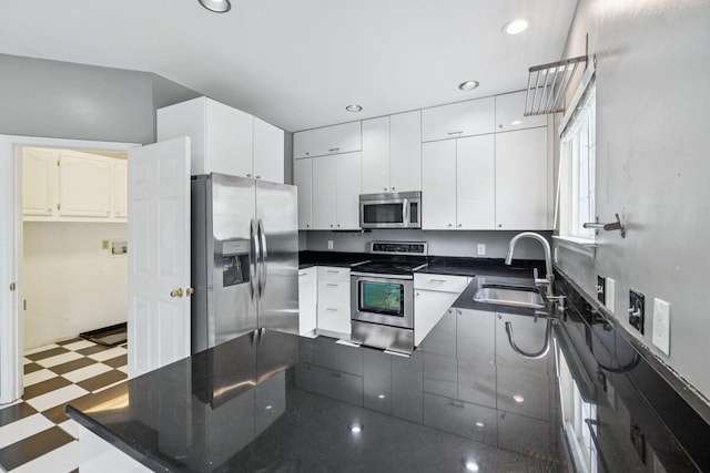 205 Caneel Cv, Hermitage, TN 37076 - kitchen with appliances with stainless steel finishes, tile patterned floors, a sink, dark countertops, and a peninsula