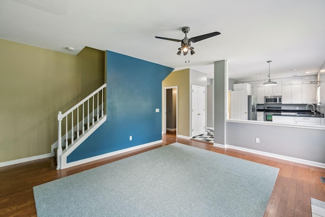 205 Caneel Cv, Hermitage, TN 37076 - unfurnished living room featuring ceiling fan, wood finished floors, baseboards, stairs, and a sink