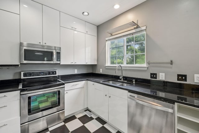 205 Caneel Cv, Hermitage, TN 37076 - kitchen featuring stainless steel appliances, a sink, white cabinetry, dark countertops, and dark flooring