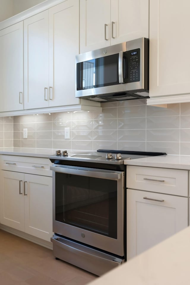 621 Live Life Ln, Nashville, TN 37207 - kitchen with appliances with stainless steel finishes, white cabinetry, decorative backsplash, and light countertops