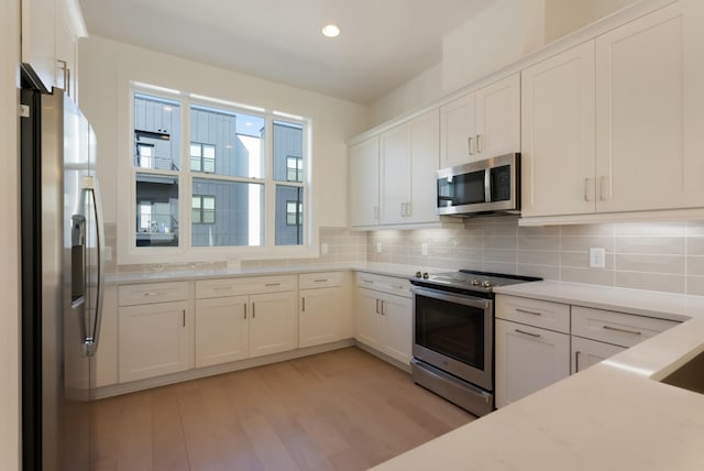 621 Live Life Ln, Nashville, TN 37207 - kitchen featuring appliances with stainless steel finishes, light countertops, white cabinetry, light wood-style flooring, and recessed lighting