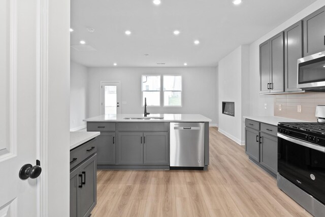 276 Subban Ct, Lebanon, TN 37087 - kitchen featuring appliances with stainless steel finishes, a sink, gray cabinetry, light countertops, and decorative backsplash