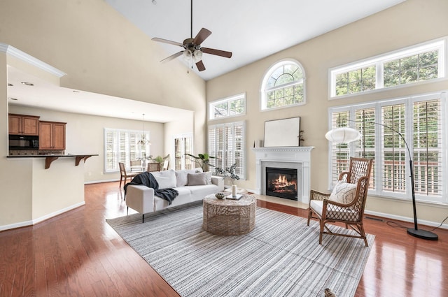 8825 Caswick Ct, Nolensville, TN 37135 - living area featuring a fireplace with flush hearth, wood finished floors, ceiling fan, a high ceiling, and baseboards