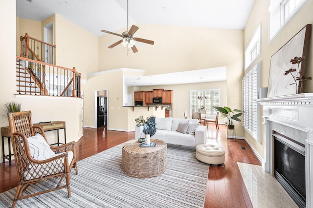 8825 Caswick Ct, Nolensville, TN 37135 - living area featuring wood finished floors, stairway, ceiling fan, high vaulted ceiling, and a high end fireplace