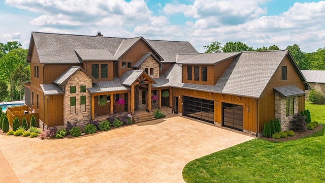 324 Lakeview Rd, Gallatin, TN 37066 - view of front facade with stone siding, decorative driveway, an attached garage, board and batten siding, and roof with shingles