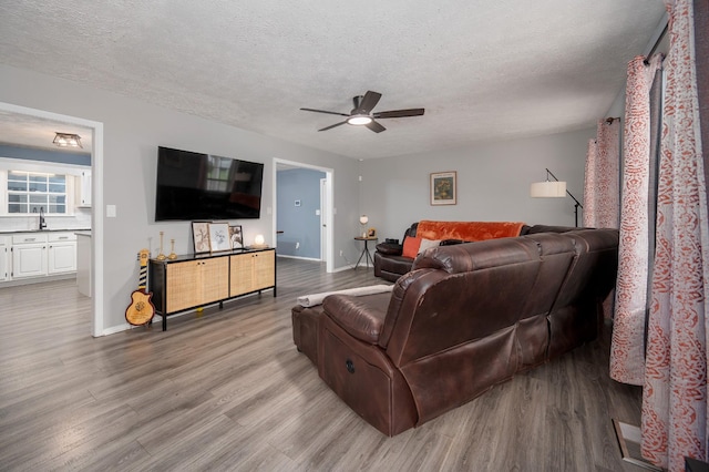 115 Pin Oaks Ln, Hohenwald, TN 38462 - living area featuring wood finished floors, a ceiling fan, a textured ceiling, and baseboards