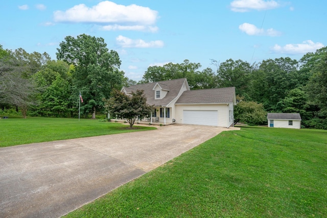 115 Pin Oaks Ln, Hohenwald, TN 38462 - view of front of house featuring concrete driveway, a front yard, an attached garage, and an outbuilding
