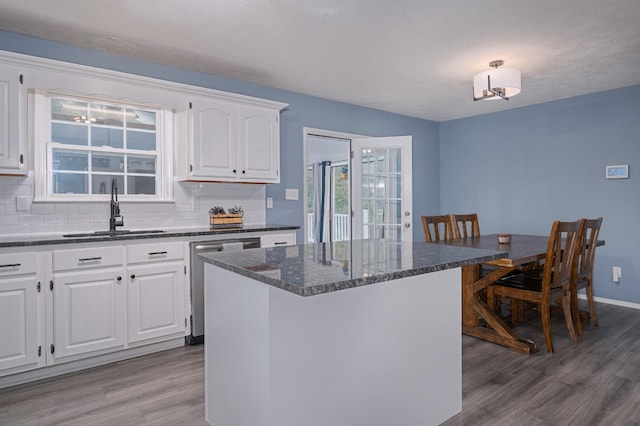 115 Pin Oaks Ln, Hohenwald, TN 38462 - kitchen featuring stainless steel dishwasher, a sink, light wood-style flooring, decorative backsplash, and white cabinets