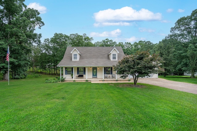115 Pin Oaks Ln, Hohenwald, TN 38462 - cape cod house featuring covered porch, driveway, a front yard, and view of scattered trees