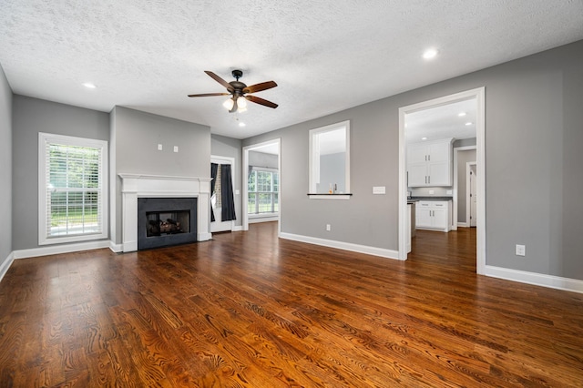 167 Lancaster St, Hillsboro, TN 37342 - unfurnished living room featuring ceiling fan, a textured ceiling, dark wood finished floors, baseboards, and a fireplace