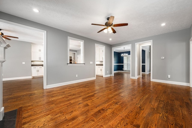 167 Lancaster St, Hillsboro, TN 37342 - unfurnished living room with ceiling fan, a chandelier, dark wood-style flooring, baseboards, and a textured ceiling