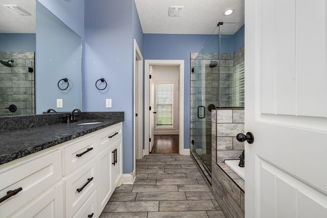 167 Lancaster St, Hillsboro, TN 37342 - bathroom featuring a textured ceiling, a stall shower, vanity, wood tiled floors, and a bathtub