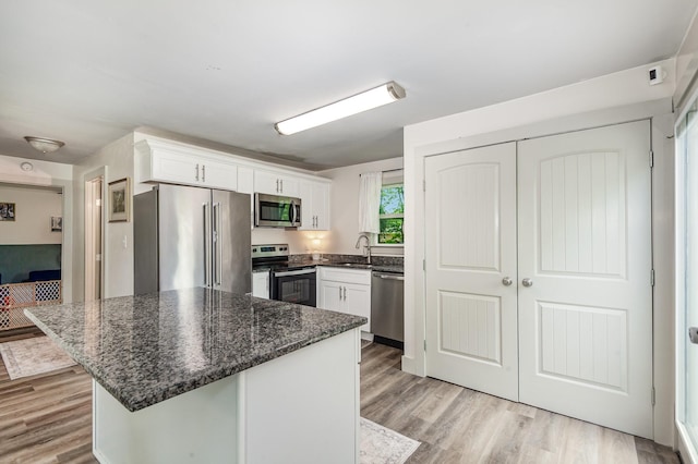 349 Dawn Dr, Cedar Hill, TN 37032 - kitchen featuring stainless steel appliances, a sink, white cabinets, light wood-type flooring, and dark stone counters