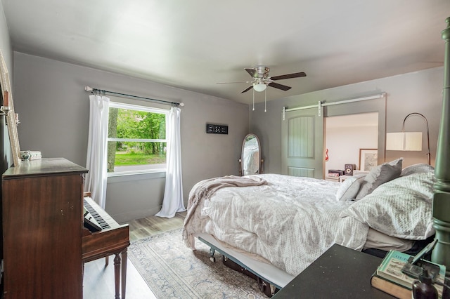 349 Dawn Dr, Cedar Hill, TN 37032 - bedroom with light wood-type flooring, a ceiling fan, and a barn door