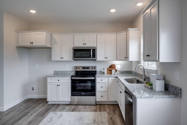 1502 Rock Springs Rd, Cumberland Furnace, TN 37051 - kitchen featuring appliances with stainless steel finishes, a sink, light wood-type flooring, white cabinets, and recessed lighting