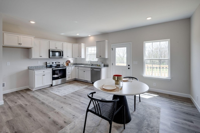 1502 Rock Springs Rd, Cumberland Furnace, TN 37051 - kitchen with appliances with stainless steel finishes, recessed lighting, white cabinets, baseboards, and light wood finished floors