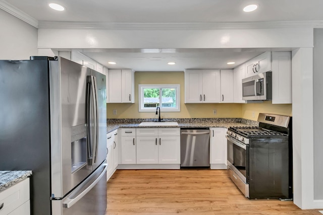 325 Francis Rd, Decherd, TN 37324 - kitchen with appliances with stainless steel finishes, a sink, ornamental molding, white cabinetry, and light wood finished floors
