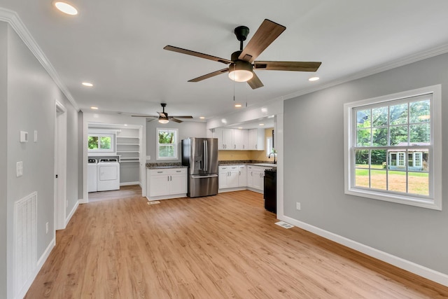 325 Francis Rd, Decherd, TN 37324 - unfurnished living room featuring washing machine and dryer, crown molding, a sink, healthy amount of natural light, and baseboards