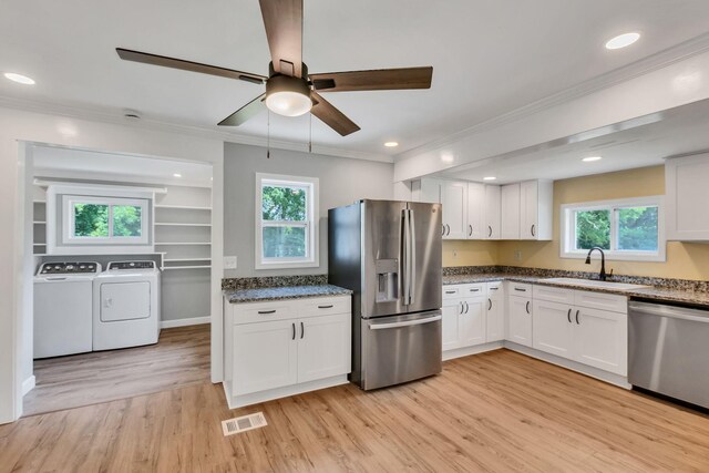 325 Francis Rd, Decherd, TN 37324 - kitchen featuring appliances with stainless steel finishes, washing machine and clothes dryer, a sink, white cabinetry, and crown molding