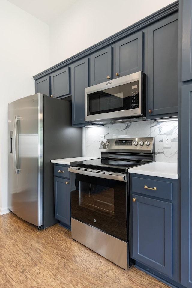 3164 Winberry Dr, Franklin, TN 37064 - kitchen featuring stainless steel appliances, light countertops, light wood-style floors, and decorative backsplash