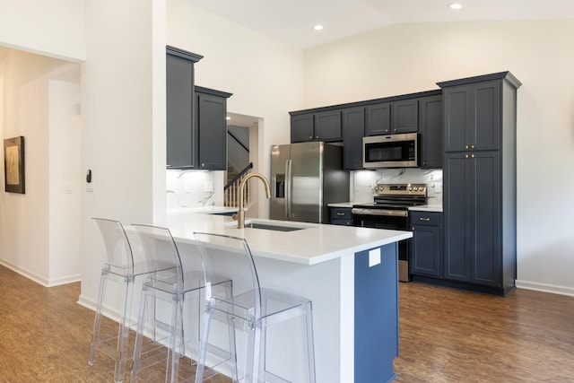 3164 Winberry Dr, Franklin, TN 37064 - kitchen with stainless steel appliances, dark wood-style flooring, a breakfast bar, baseboards, and high vaulted ceiling