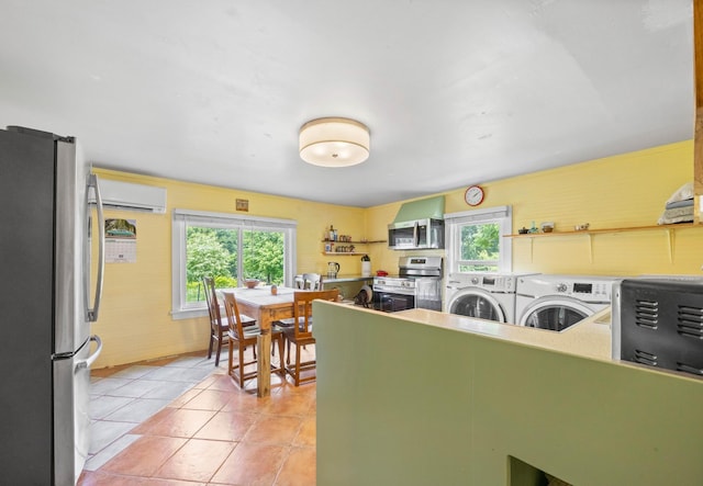 379 Gunson Ridge Rd, Cumberland City, TN 37050 - kitchen featuring appliances with stainless steel finishes, washer and dryer, plenty of natural light, and a wall unit AC