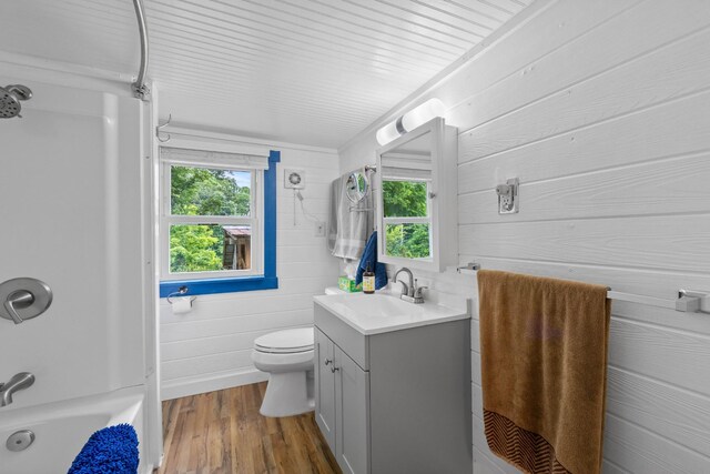 379 Gunson Ridge Rd, Cumberland City, TN 37050 - full bathroom featuring vanity, wood walls, wood finished floors, toilet, and shower / bathtub combination