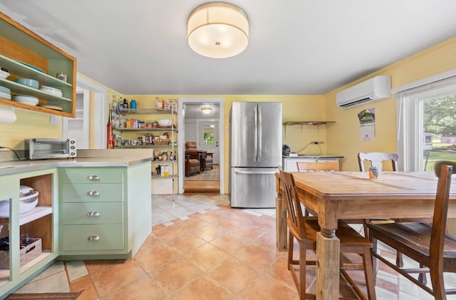 379 Gunson Ridge Rd, Cumberland City, TN 37050 - kitchen with freestanding refrigerator, green cabinets, a wall unit AC, open shelves, and light countertops