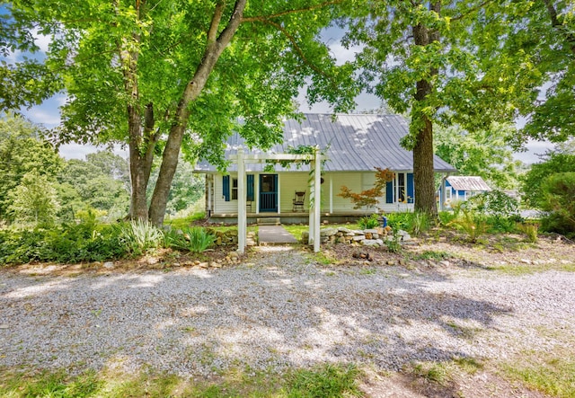 379 Gunson Ridge Rd, Cumberland City, TN 37050 - view of front of home with covered porch, metal roof, and a chimney