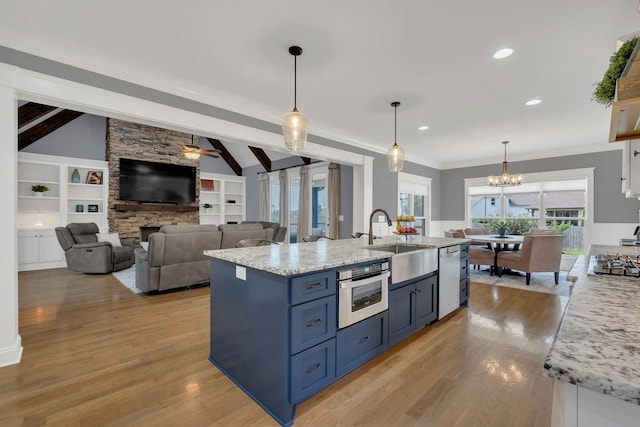 2732 Cherrydale Dr, Lebanon, TN 37087 - kitchen with a sink, blue cabinets, appliances with stainless steel finishes, a stone fireplace, and light wood finished floors