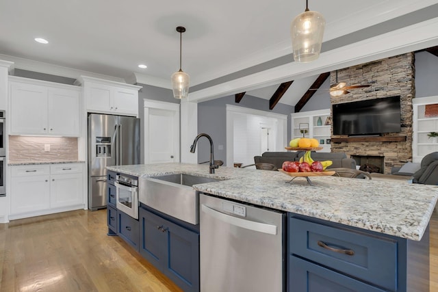 2732 Cherrydale Dr, Lebanon, TN 37087 - kitchen with appliances with stainless steel finishes, blue cabinetry, a sink, open floor plan, and white cabinets